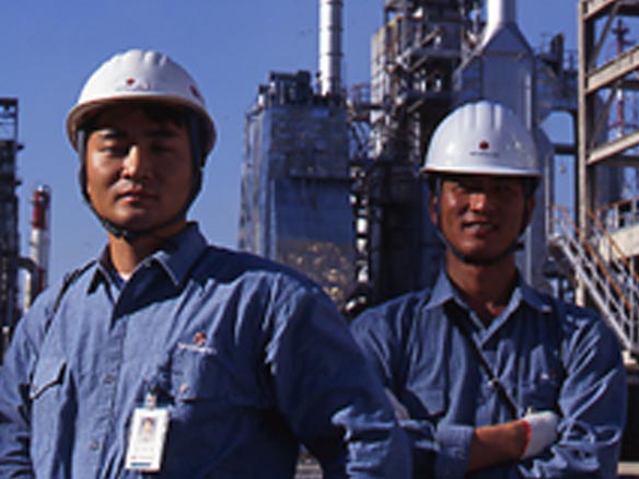 Caltex engineers standing in front of factory stacks 