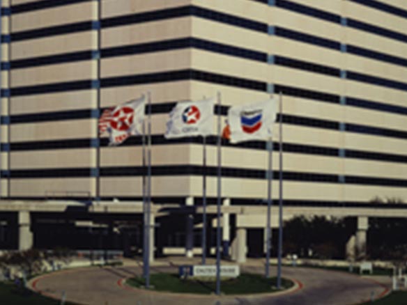 Texaco Caltex and Chevron flags flying in front of an office building