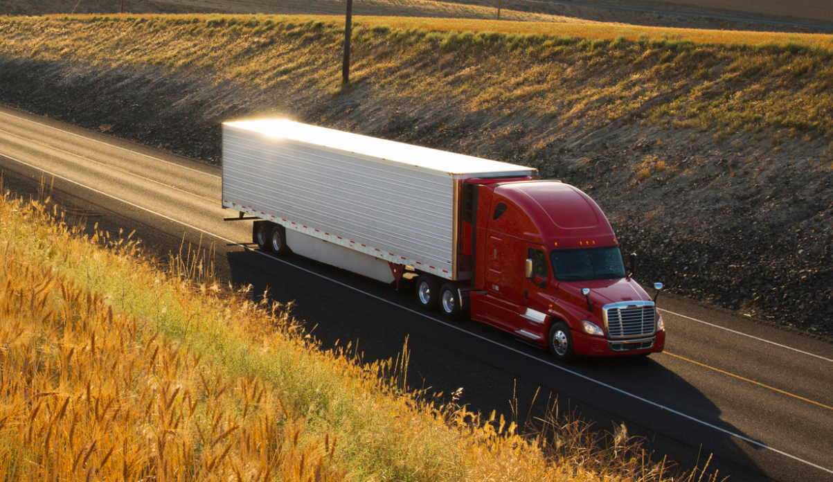 Red container truck driving down road