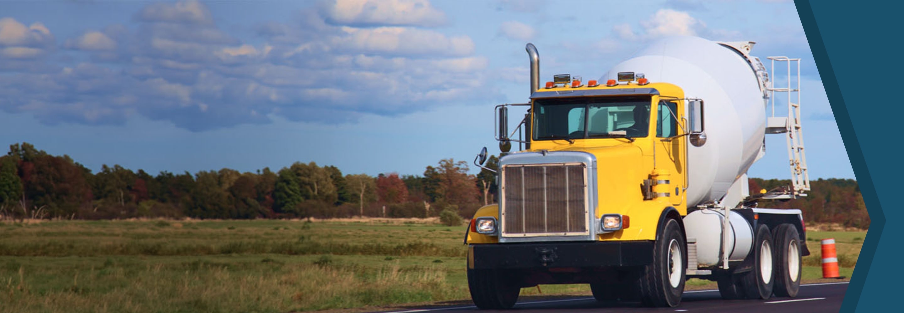 Yellow cement truck driving down road