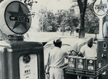 Black and white photo of two Caltex attendants fuelling up a car