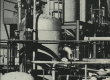 Black and white photo of fuel factory pipes and tanks