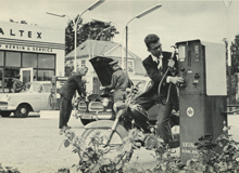 Black and white photo of a man fuelling up and mechanics repairing a car 