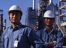 Caltex engineers standing in front of factory stacks 