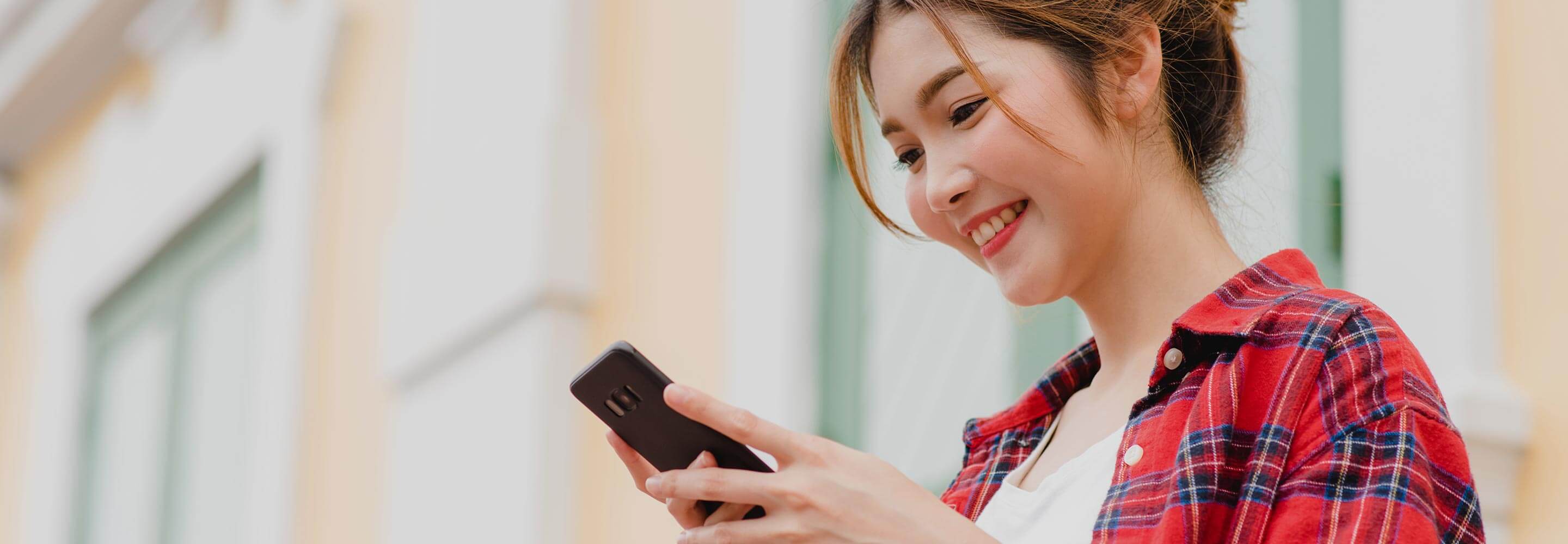 Woman smiling while using a mobile phone